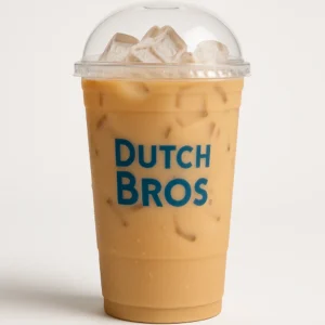 Tall clear Dutch Bros cup of creamy decaf Ceylon iced tea with milk and cream, and white background.

