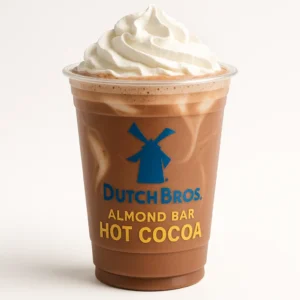 Dutch Bros Almond Bar Hot Cocoa with white chocolate and almond flavor topped with whipped cream on white background