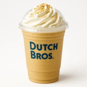 Dutch Bros Banana Bread Shake with banana and hazelnut flavors, topped with whipped cream, on a white background.