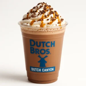 Dutch Bros Dutch Canyon Hot Cocoa with white and dark chocolate, macadamia nut flavor, whipped cream, and caramel drizzle on white background