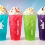 Colorful Dutch Bros Rebel energy drinks in official logo cups with whipped cream and stylish pastel background.