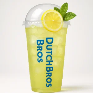 Tall clear Dutch Bros cup of pale yellow-green iced green tea lemonade with lemon and mint garnish, and white background.

