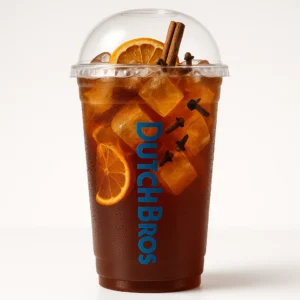 Tall clear Dutch Bros cup of deep amber-brown iced cinnamon spice tea with orange slices, cinnamon stick, cloves garnish, and white background.

