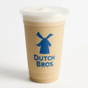 Dutch Bros Oat Milk Latte in a tall clear cup with light beige color on a white background