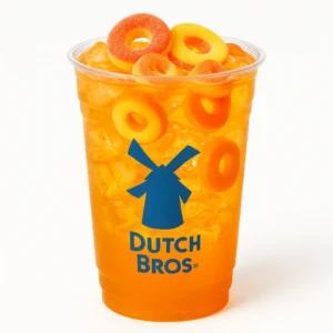 Peach Ring Rebel Dutch Bros energy drink with bright orange color and peach ring candy, in a modern clear cup.

