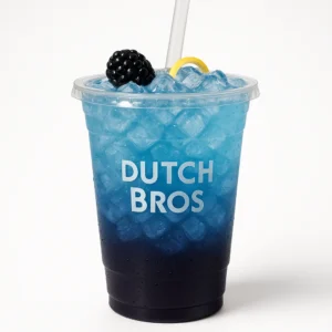 Modern clear Dutch Bros plastic cup of deep purple and blue Starry Night iced drink with blackberry and blue raspberry flavors, fruit garnish, and white background.


