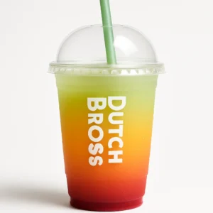 Modern frosted Dutch Bros cup with domed lid containing layered red, orange, and green Stop Light drink flavors of pomegranate, passion fruit, and kiwi on a white background.

