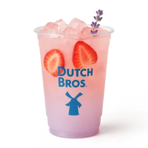 Strawberry Lavender Lemonade in a clear Dutch Bros cup with ice, fresh strawberries, and a light lavender hue.

